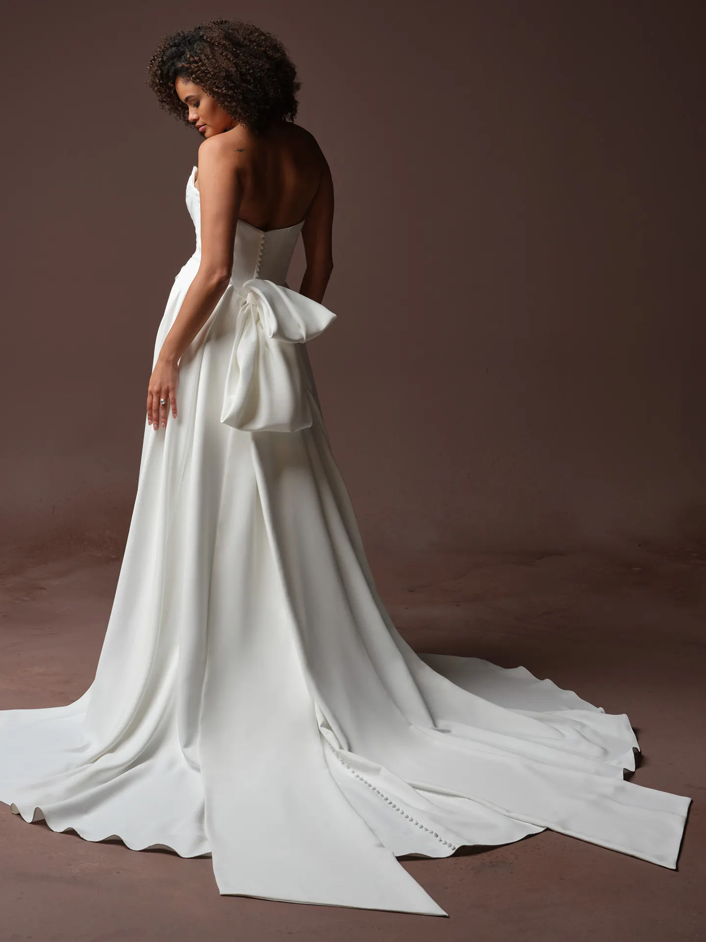 Maggie Sottero Calliope back view satin A-line dress with large bow detail.