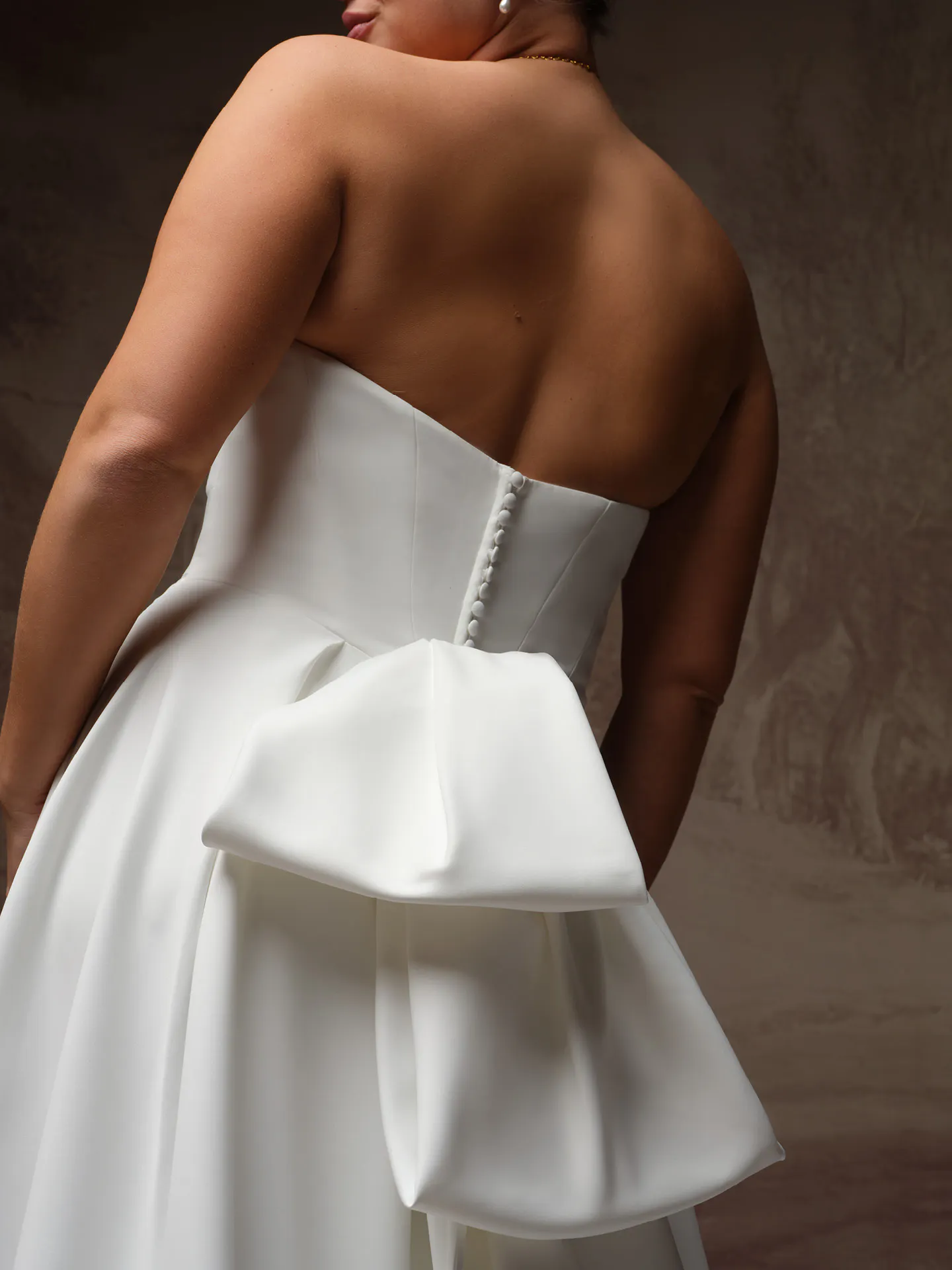 Calliope back view satin A Line dress with large bow detail.