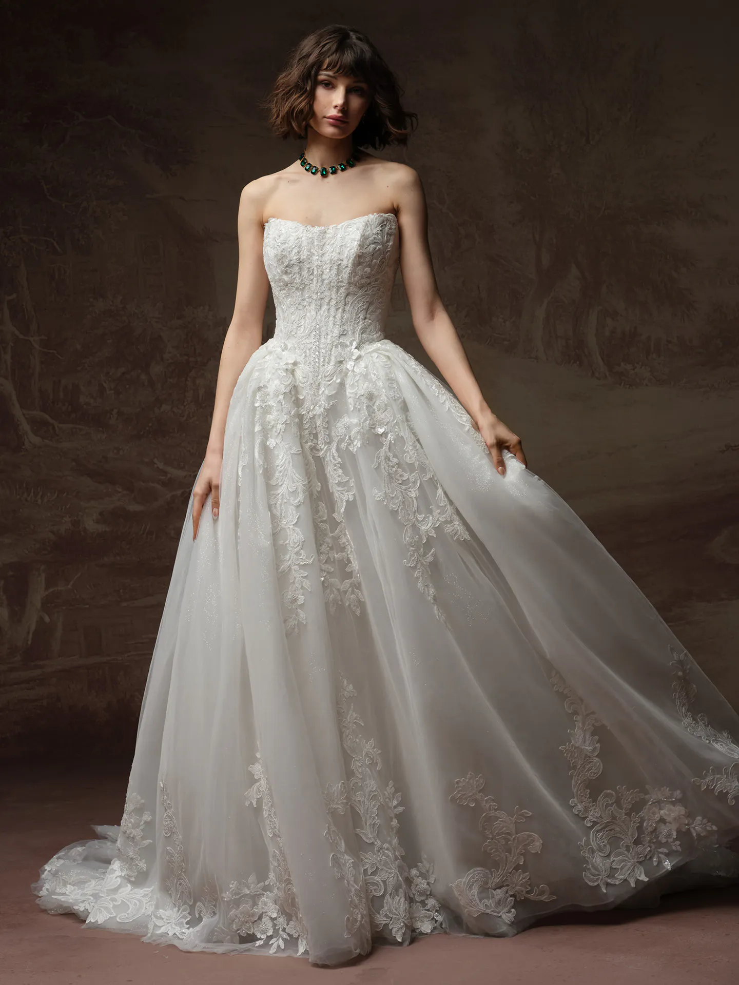 Maggie Sottero Lyra front view: strapless tulle ballgown with lace details.