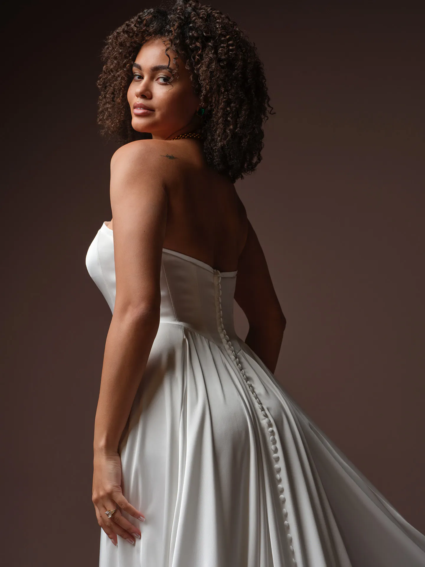 Maggie Sottero Tiffany side view, strapless A Line wedding dress with button detail.