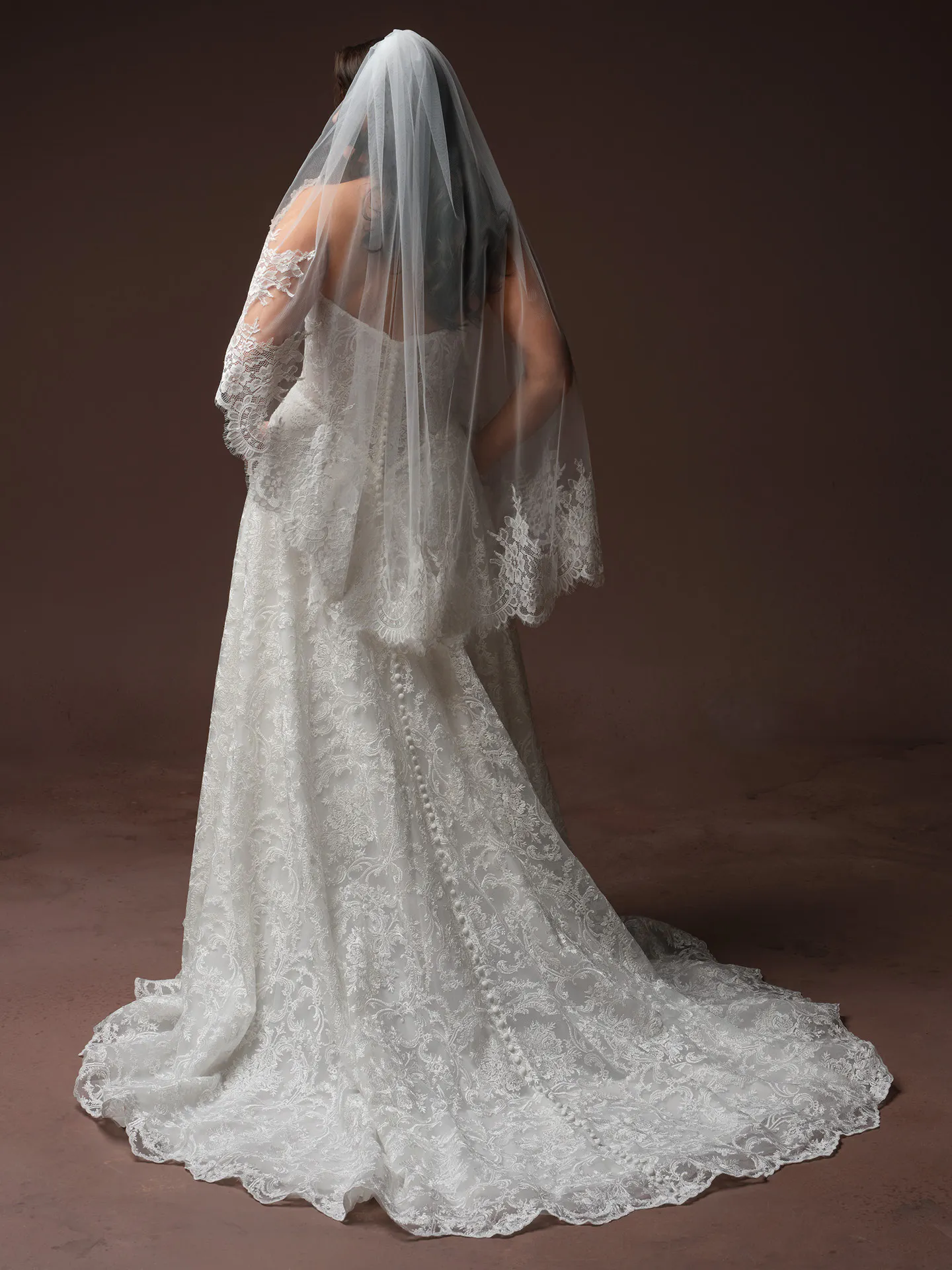 Zahia back view lace wedding gown with chapel train and veil.