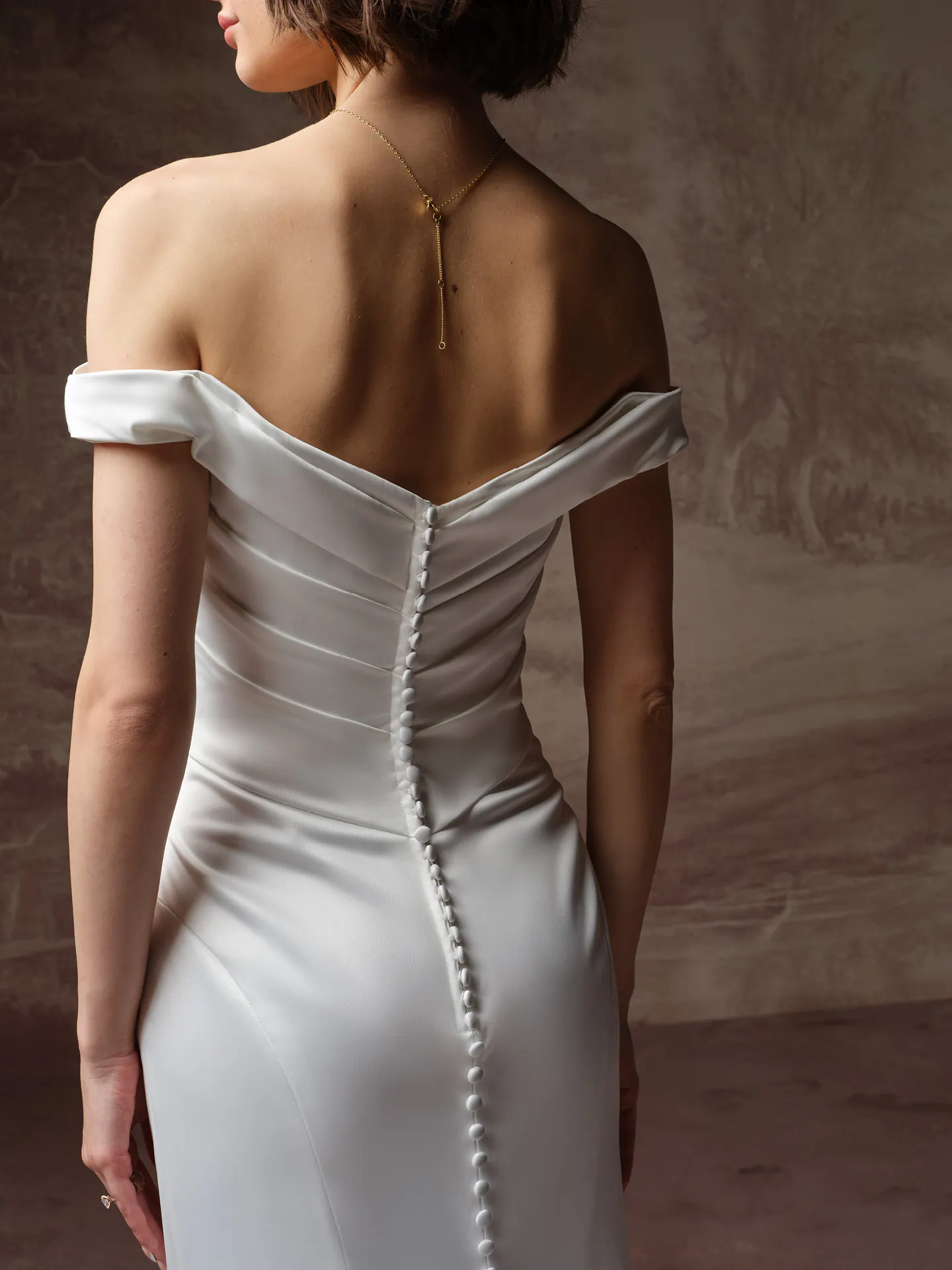 Rebecca Ingram Clementine, back view wedding dress off-shoulder button detail.