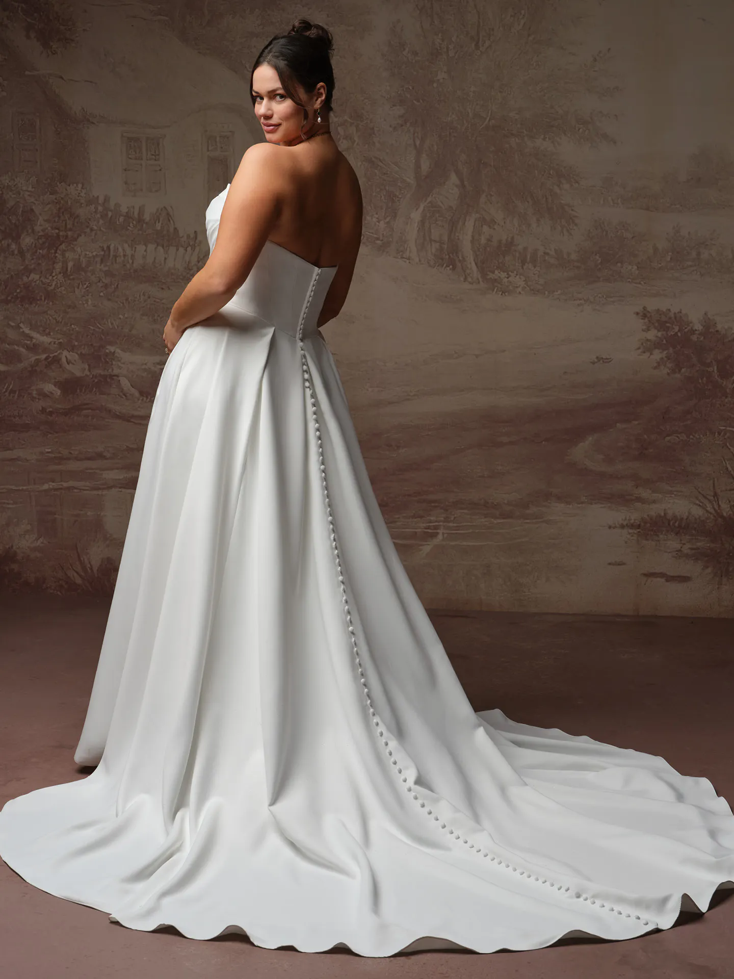 Maggie Sottero Calliope back view satin A Line wedding dress trailing buttons elegant setting.